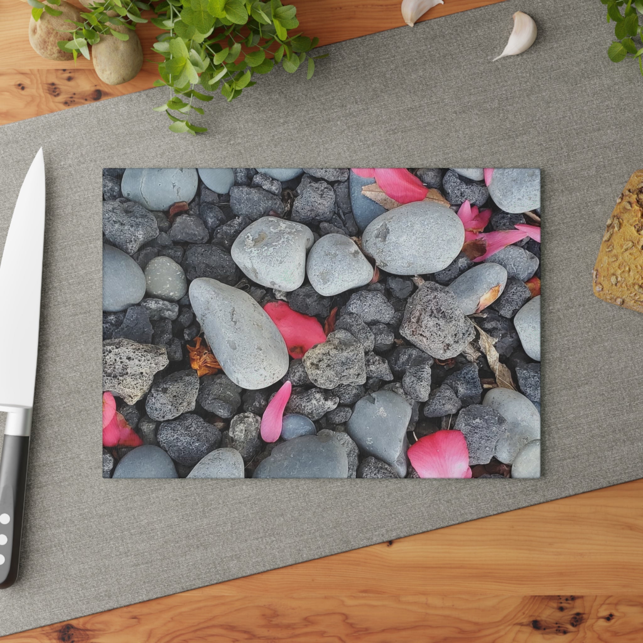 Tabla de cortar de cristal "Pétalos rosas sobre piedras de río" | Decoración floral de cocina con motivos de piedra