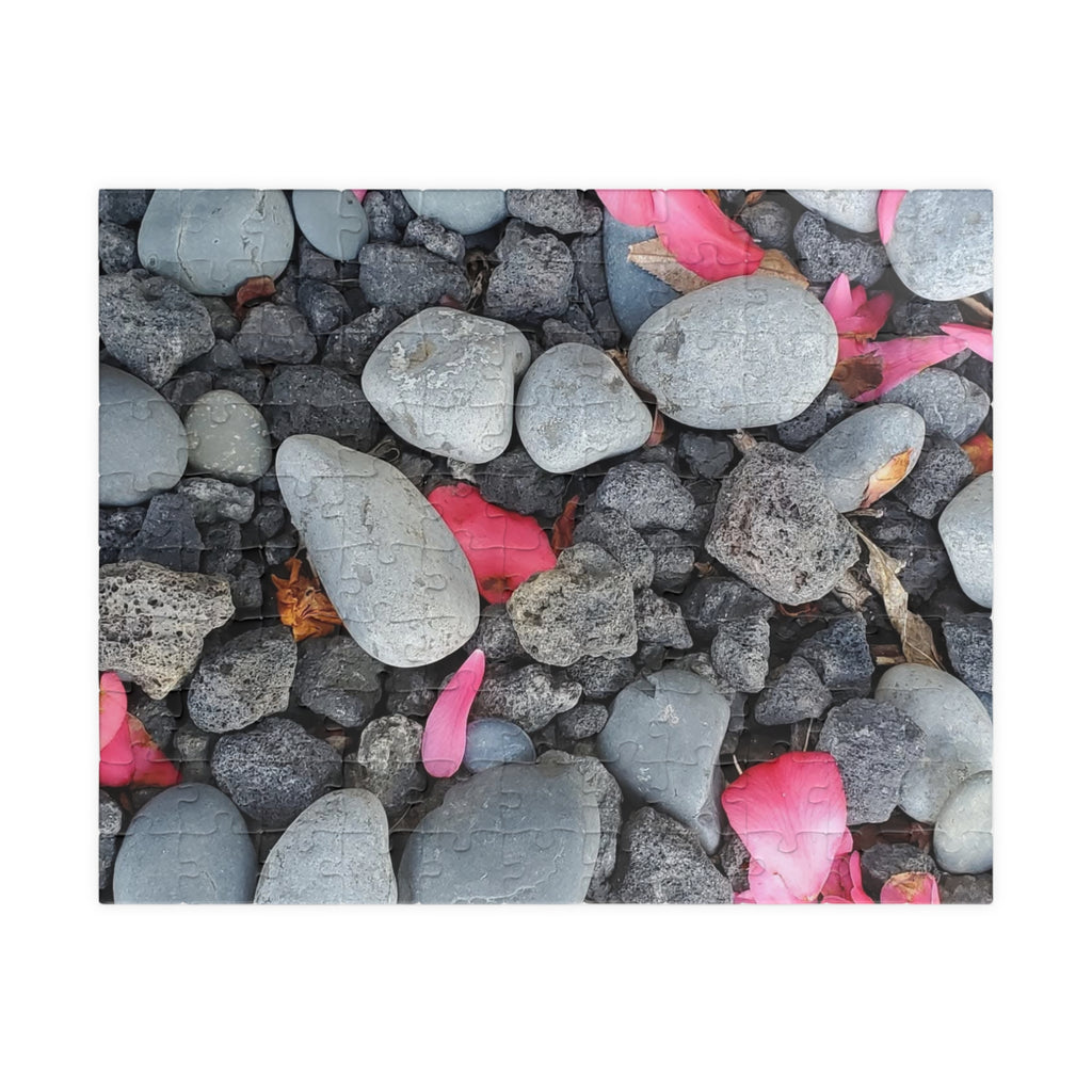 Rompecabezas de pétalos rosas sobre rocas de río