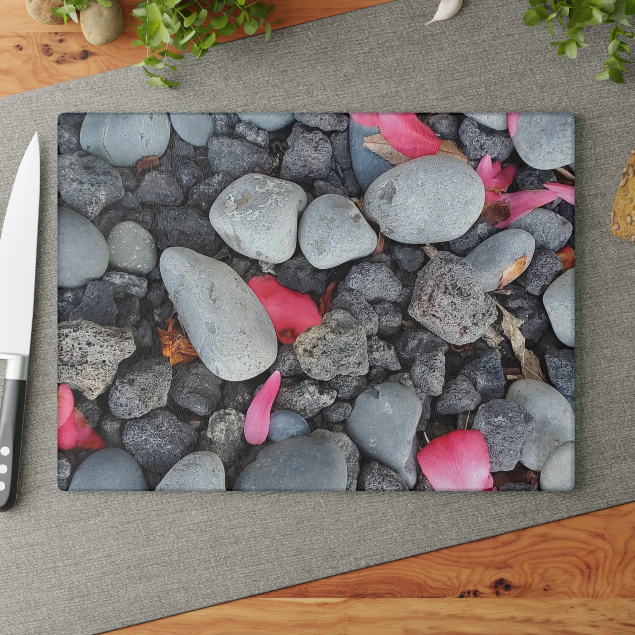 Tabla de cortar de cristal "Pétalos rosas sobre piedras de río" | Decoración floral de cocina con motivos de piedra