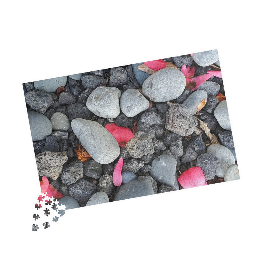 Rompecabezas de pétalos rosas sobre rocas de río