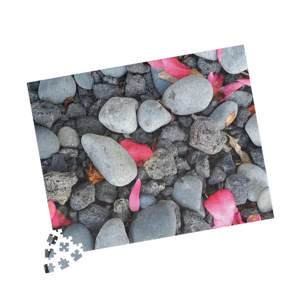 Rompecabezas de pétalos rosas sobre rocas de río